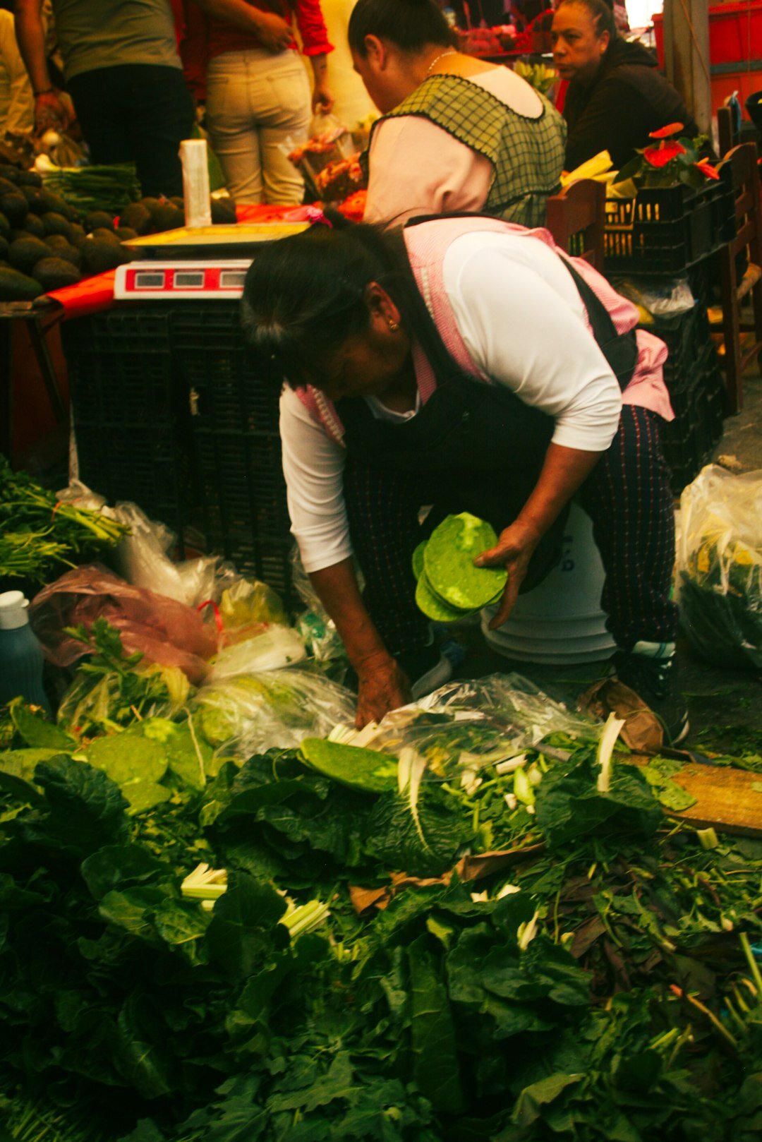 Vendor arranging vegetables at a local market stall
