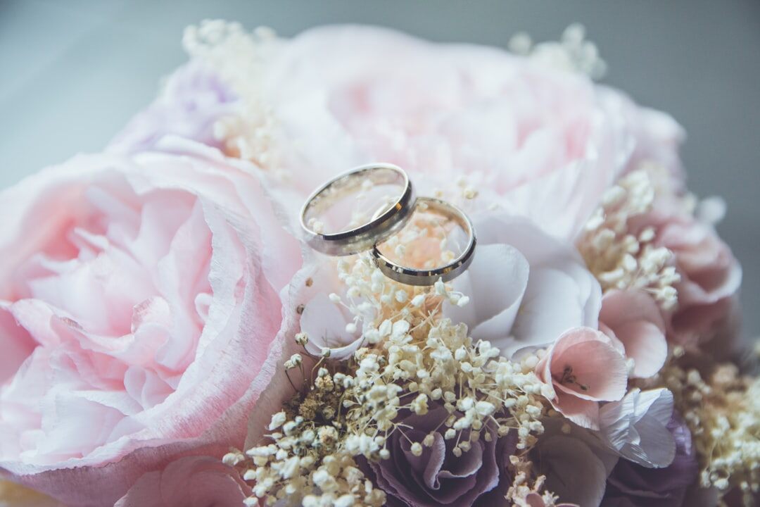 Close-up of wedding rings on a bouquet of flowers