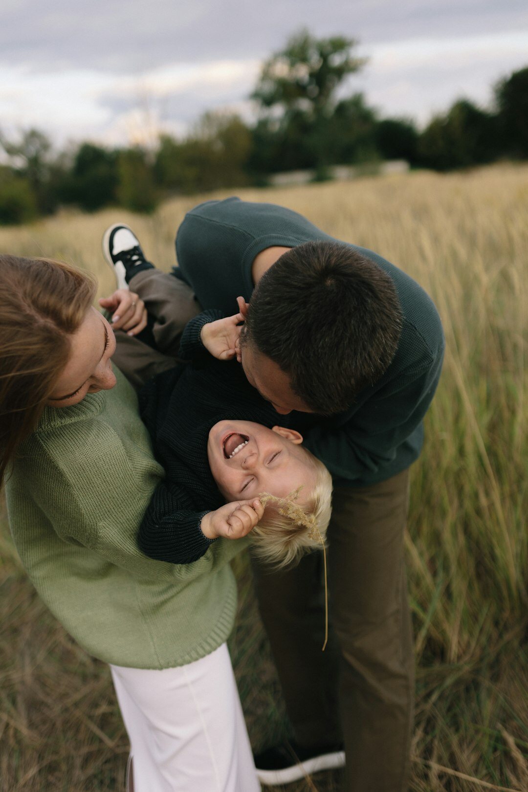 Family with two children laughing together outdoors